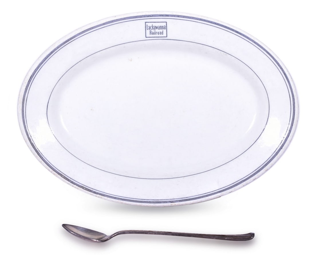 Lackawanna Railroad Buffalo China Oval Platter and Silver Iced-Tea Spoon: Two dining car items for the Lackawanna Railroad including an 11 1/2" oval china platter in the Buffalo pattern, top marked with the Lackawanna Railroad box logo, and bottom stamped Buffalo China 1922