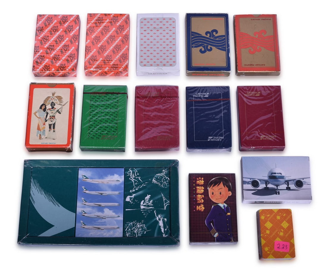 Sixteen Cathay Pacific Airline and Dragonair Playing Card Decks: A large group of mostly new old stock playing cards in original cellophane packaging for Cathay Pacific Airlines of Hong Kong and its subsidiary Dragonair, in various designs. The two opened decks wit