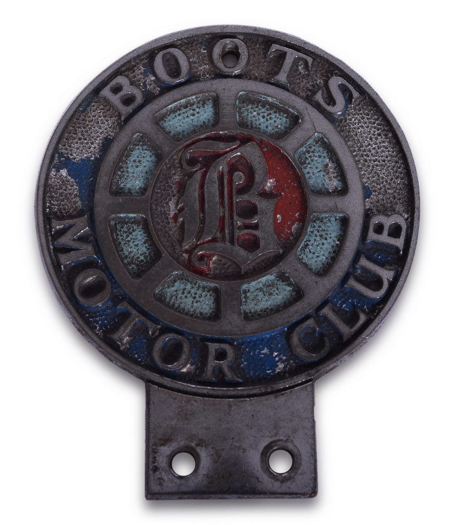 Boots Motor Club Chrome Badge / License Plate Topper: Cast Boots Motor Club badge from England. The badge has been chromed with a pebbled background which was then painted. There is some paint wear and light wear to the chrome. The badge measures 3" x 3 