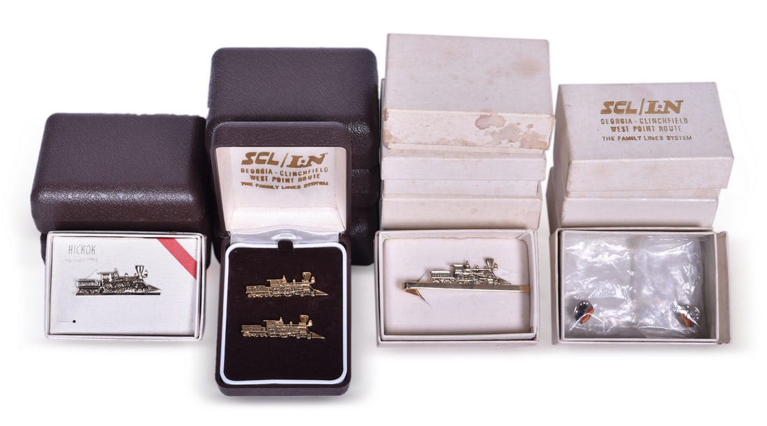 Twenty Louisville and Nashville Railroad The General Tie Bar and Seaboard Coast Line Pins: Group includes a collection of eighteen new old stock The General steam locomotive tie bar clips and pins in original packaging. The brass plated tie bars measure 1 5/8" and show minimal to no signs o
