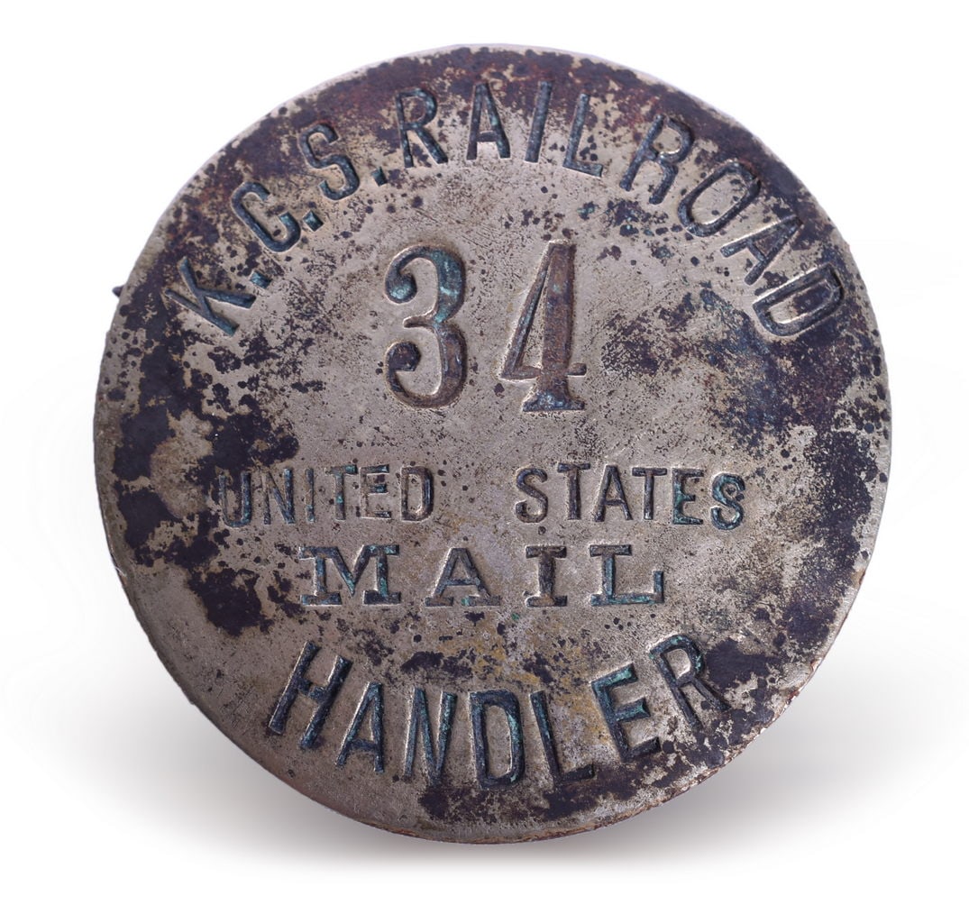 Kansas City Southern Railroad United States Mail Handler Badge Number 34: A round nickel badge with black enamel lettering for KCS Railroad with badge number 34 and Mail in serif font. The badge shows heavy discoloration and plating wear on the front. The back shows heavy o