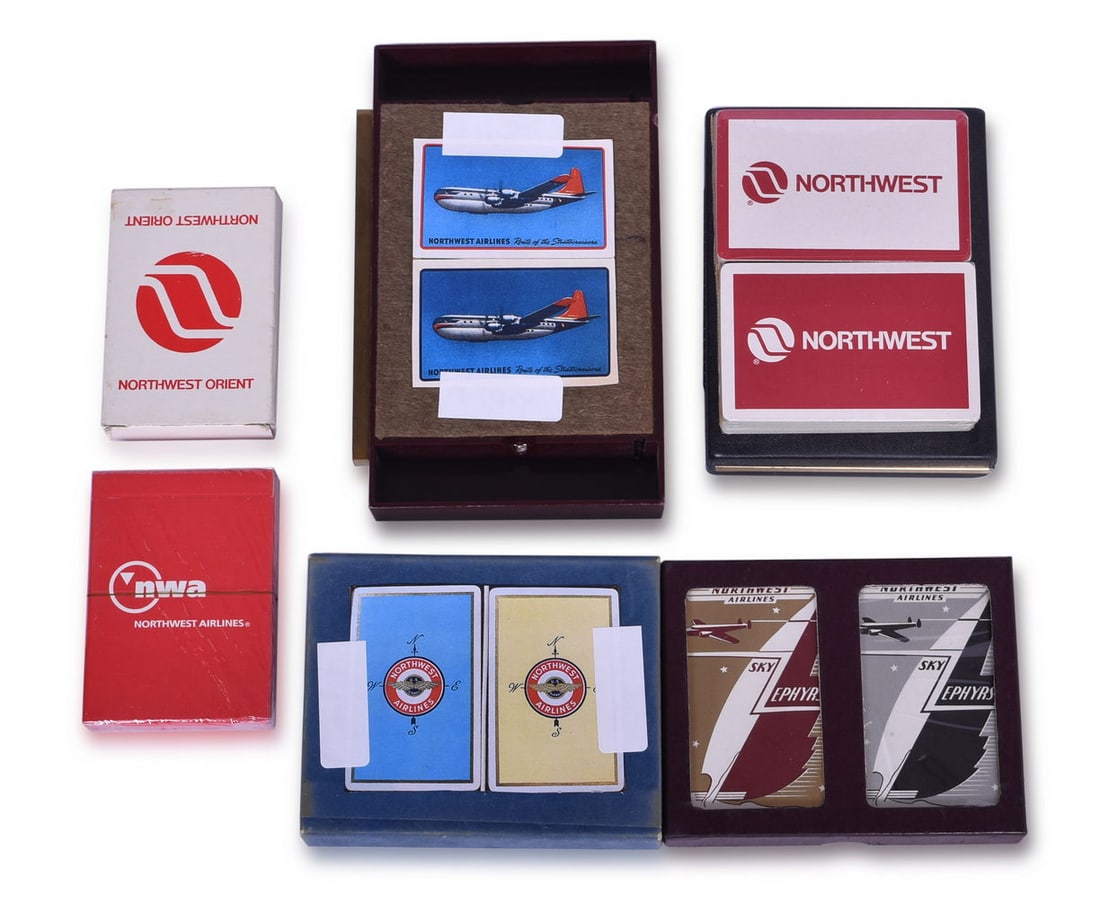 Ten Northwest Airlines Playing Card Decks - Sky Zephyrs, Northwest Orient, Route of the: Collection of playing cards advertising Northwest Airlines. Includes a sealed double deck of the Sky Zephyrs design in both silver and gold, showing cracking to the silver cellophane.Double deck by Br