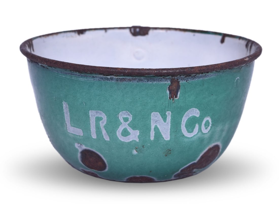 Louisiana Railway & Navigation Company Enamelware Drinking Cup: A 2" tall x 4" diameter graniteware drinking cup side marked with LR&N Co in white on green porcelain enamel. Shows moderate signs of age and use with missing rim enamel, wear to the handle, chips and