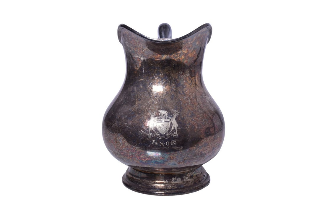 Temiskaming and Northern Ontario Railway Silver Water Pitcher: A scarce silver plate water pitcher from the 1920s for the Temiskaming and Northern Ontario Railroad of Canada, side marked on the front with engraved Ontario coat of arms and T&NOR. Bottom stamped To
