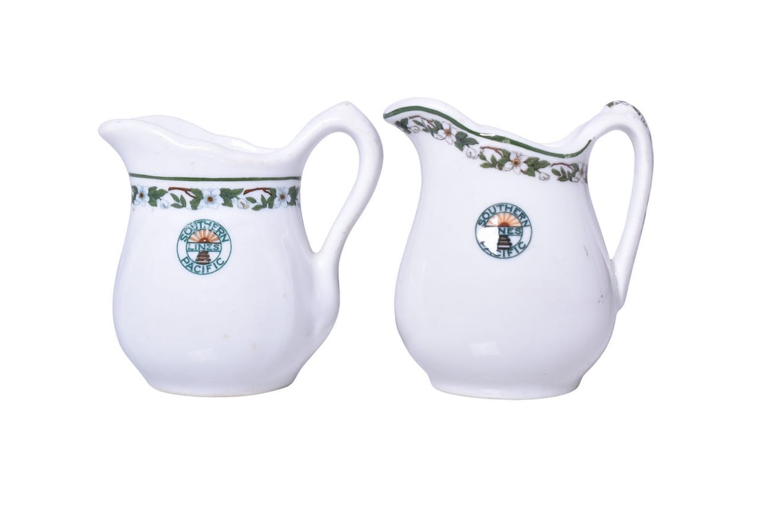 Pair of Southern Pacific Railroad China Sunset Cream Pitchers: A pair of handled creamers for the Southern Pacific Lines Railroad dining car in the Sunset pattern, two different styles. Includes a 3 1/2" tall pitcher with border along the rim showing mild use wit