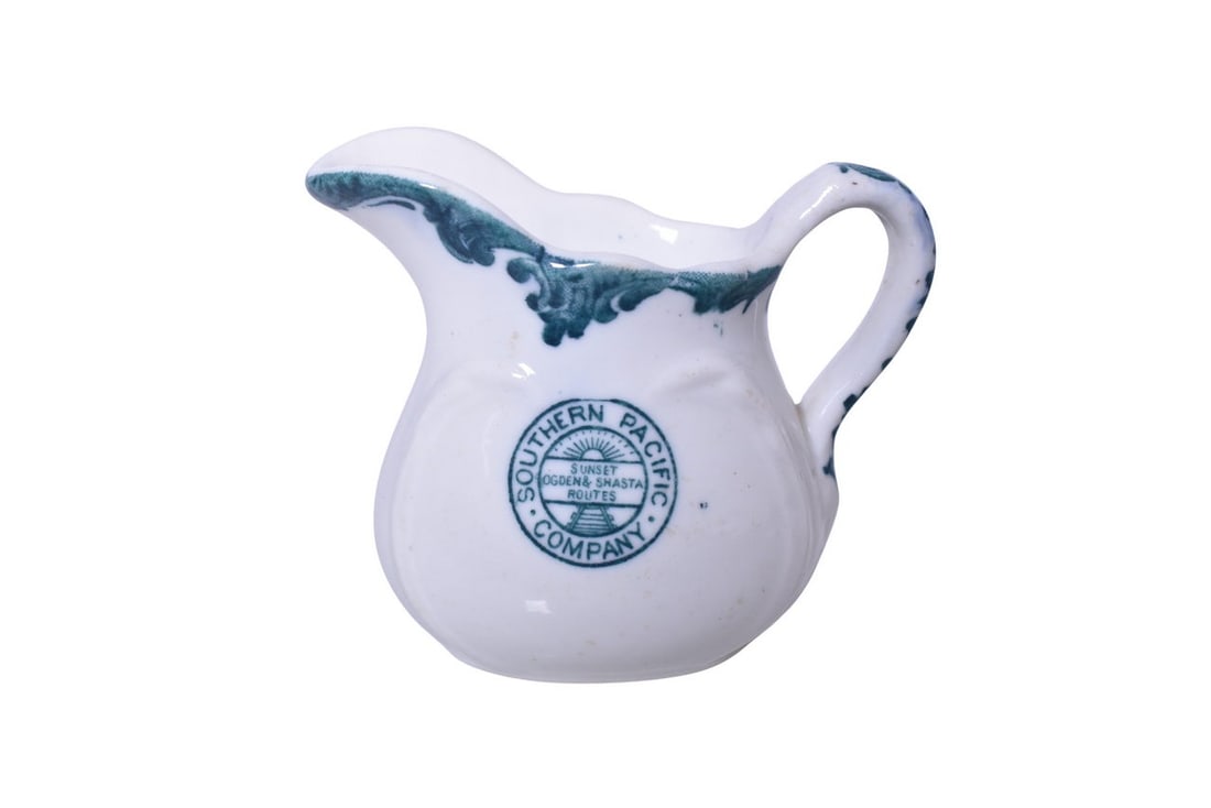 Southern Pacific Railroad China Harriman Blue Creamer: A 3 1/4" tall cream pitcher for the Southern Pacific Railroad in the Harriman Blue Top Logo pattern, side marked with the Sunset Ogden & Shasta Routes logo, by Maddock's. Shows some tiny light scratch