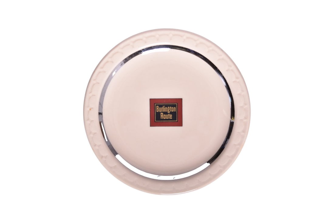 1934 CB&Q Burlington Route Railroad China Pioneer Zephyr 5 1/2" Plate: A scarce 5 1/2" china plate for the Chicago Burlington and Quincy Railroad in the Zephyr pattern, top marked with the Burlington Route box logo and silver stripe detail, bottom stamped Syracuse Patent