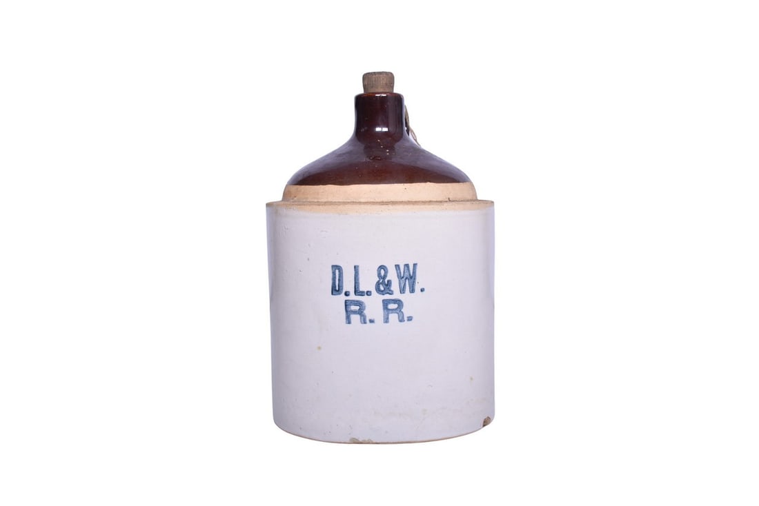 Delaware Lackawanna and Western Railroad Stoneware Jug: Stoneware jug with D.L.&W. R.R. stamped on the front. Jug measures roughly 10 5/8" tall and about 7 3/16" in diameter. One small chip along bottom edge. Minor chipping at mouth, and minor glaze flaws 
