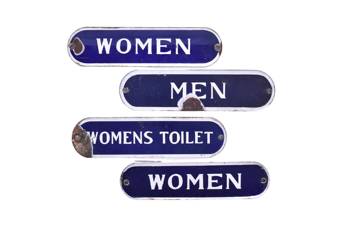 Four Porcelain Railroad Restroom Signs - Men, Women and Womens Toilet: Four 10" long porcelain restroom signs, two of them roughly 2 11/16" tall and two of them roughly 2 1/2" tall. The Womens Toilet sign has a 1 1/4" damaged section on the left side, the Men sign has a 