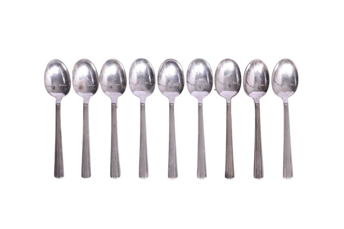 Nine New York Central Lines Dining Car Silver Teaspoons: This collection of silverware is all bottom stamped "International Silver" and each piece bears the "NYC" logo of the New York Central Lines. These 9 teaspoons show evidence of use including nicks, sc