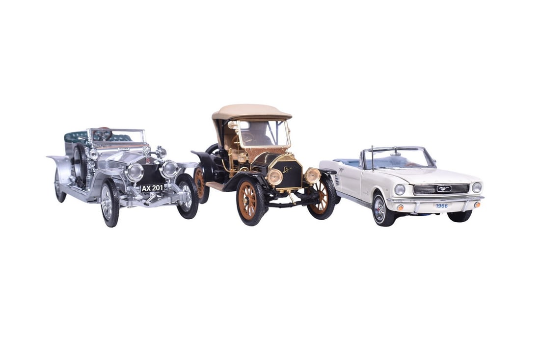 Three 1:24 scale diecast models: a Franklin Mint 1907 Rolls Royce, a Franklin Mint 1910 Cadillac: Three 1:24 scale diecast models: a Franklin Mint 1907 Rolls Royce, a Franklin Mint 1910 Cadillac Roadster, and a Danbury Mint 1966 Ford Mustang. Rolls Royce comes with its original wood and plastic di