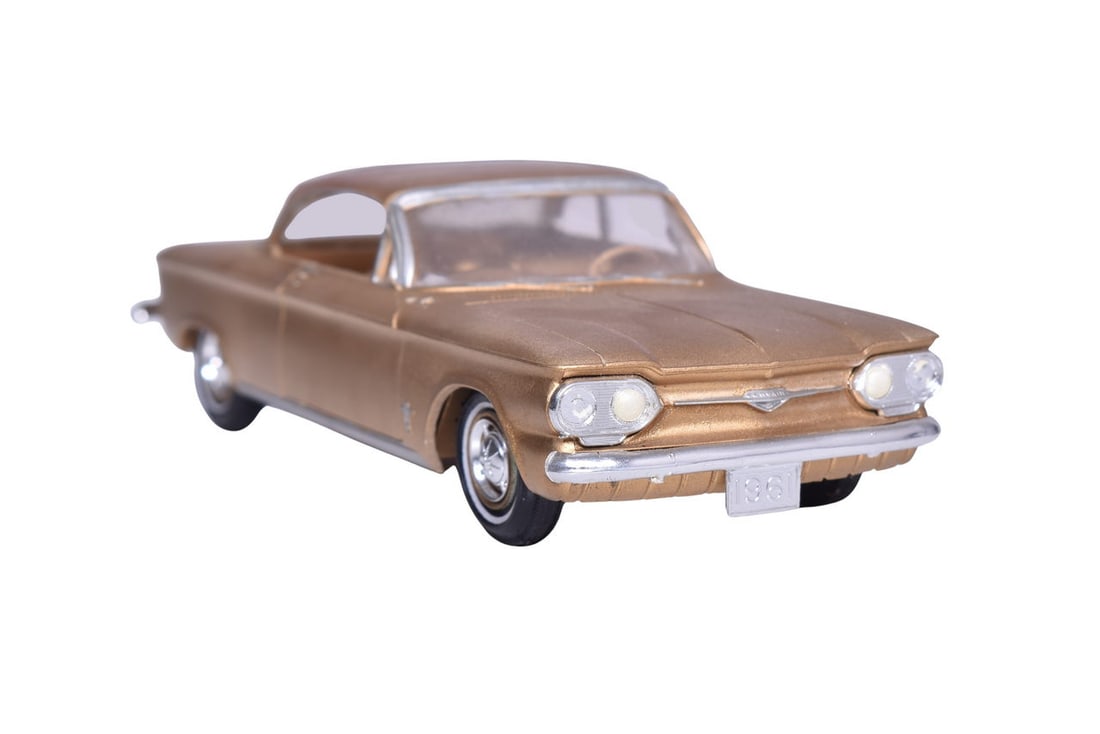 SMP plastic / resin roughly 1:24 scale model of a 1961 Chevrolet Corvair in gold. No original: SMP plastic / resin roughly 1:24 scale model of a 1961 Chevrolet Corvair in gold. No original packaging, model is missing two headlights, a taillight, the radio antenna and the passenger side window c