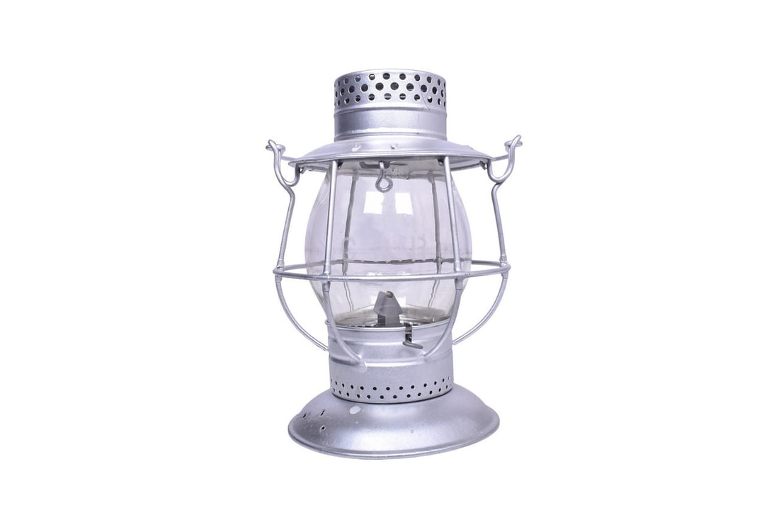 Lantern has been recently repainted silver, and aside from three holes in the bell bottom, presents: Lantern has been recently repainted silver, and aside from three holes in the bell bottom, presents well. Fuel pot and fount are present. Globe is a Macbeth with MEG Co 25 cast on the back near the to