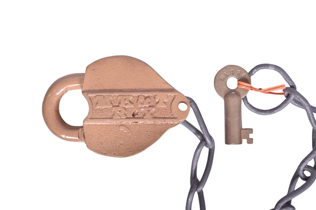 Heart shaped lock with MK&T RY cast in a panel on the front. Lock has been painted tan, but is: Heart shaped lock with MK&T RY cast in a panel on the front. Lock has been painted tan, but is likely brass underneath. Key cover is present and cast with "Close The Lock To Get Key Out", and the 