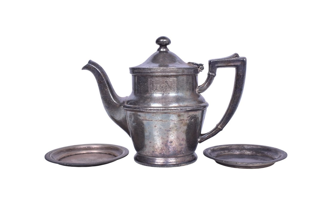 Includes a silver teapot with hinged lid, side marked with L&N box logo, bottom stamped: Includes a silver teapot with hinged lid, side marked with L&N box logo, bottom stamped International Silver Co. Silver Soldered 05002C 10 oz dated 1961. Shows heavy tarnish, scratches, and dings.