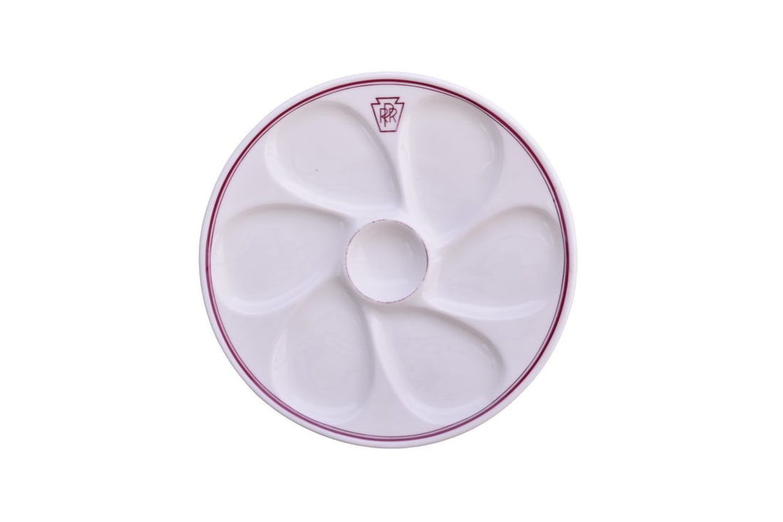 An 8 7/8" dining car china oyster plate with 6 wells and center sauce for Pennsylvania Railroad in: An 8 7/8" dining car china oyster plate with 6 wells and center sauce for Pennsylvania Railroad in the Keystone pattern with red or dark magenta detail, top marked with PRR keystone and bottom stamped