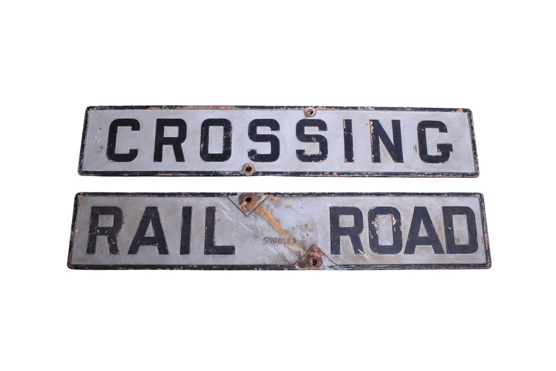 Two cast iron Railroad Crossing crossbuck signs, each measuring 48" x 9". Signs are double-sided: Two cast iron Railroad Crossing crossbuck signs, each measuring 48" x 9". Signs are double-sided with one side reading "Rail Road" and the other side reading "Crossing". Cast number T186106. Looks to 