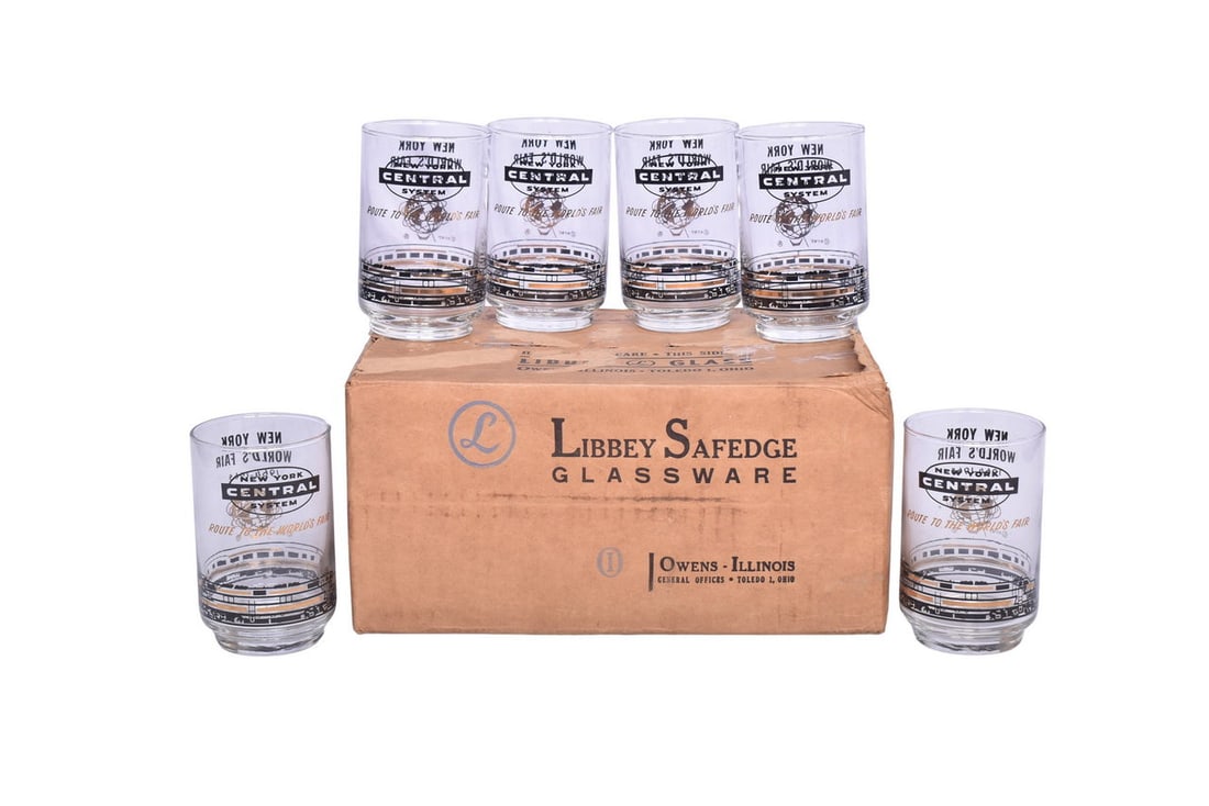 Six New York Central Railroad 12 ounce beverage glasses with the original master carton. Glasses: Six New York Central Railroad 12 ounce beverage glasses with the original master carton. Glasses show a locomotive wrapped around the bottom, "New York Central System" logo and "Route to the World's F