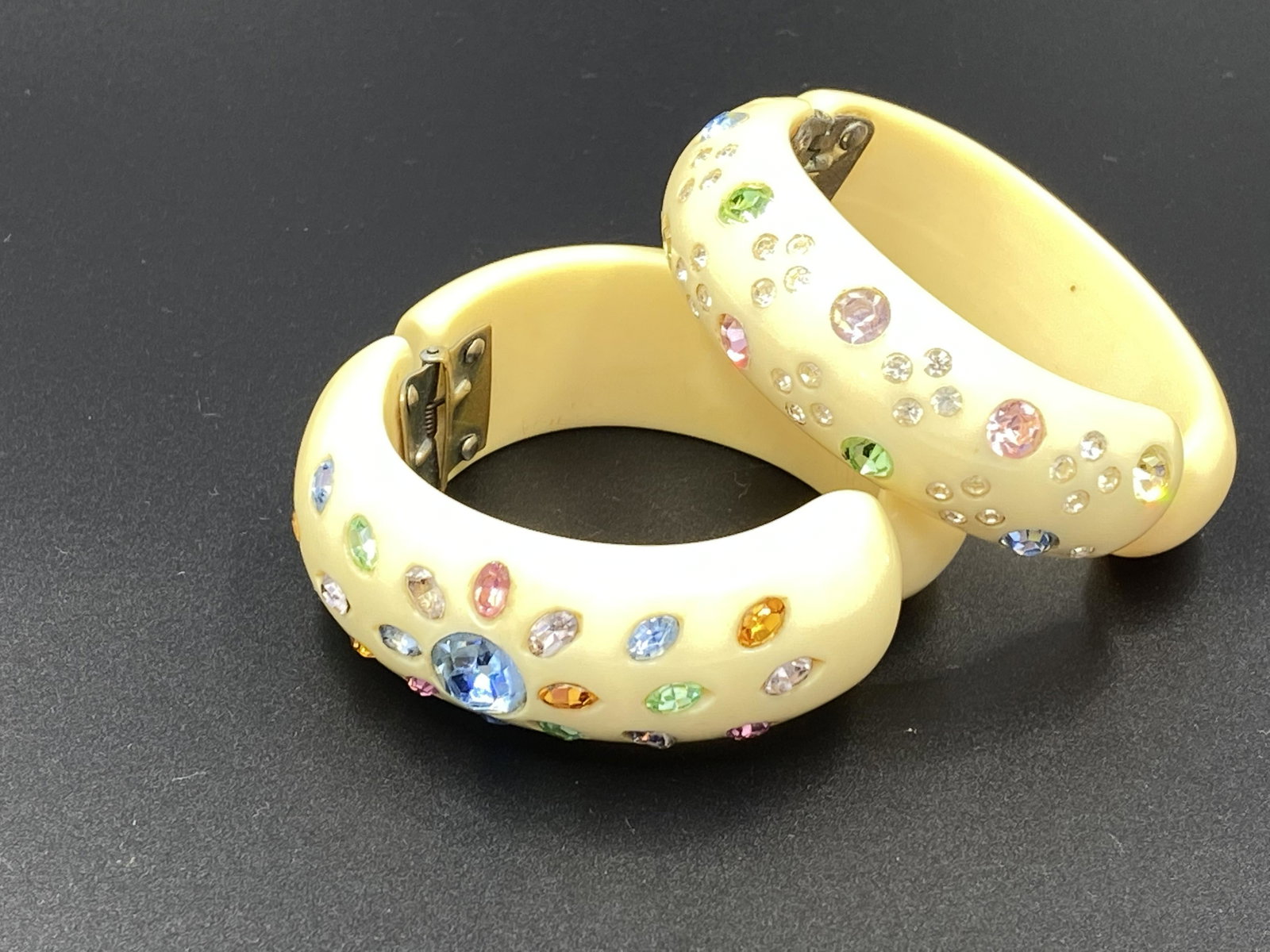 Two Ivory Thermoset Rhinestone Hinged Clampers: For exact dimensions please refer to the attached dimensions sheet. Bakelite was an early plastic resin, developed by Leo Baekeland in 1907. Originally used for industrial purposes thanks to its abili