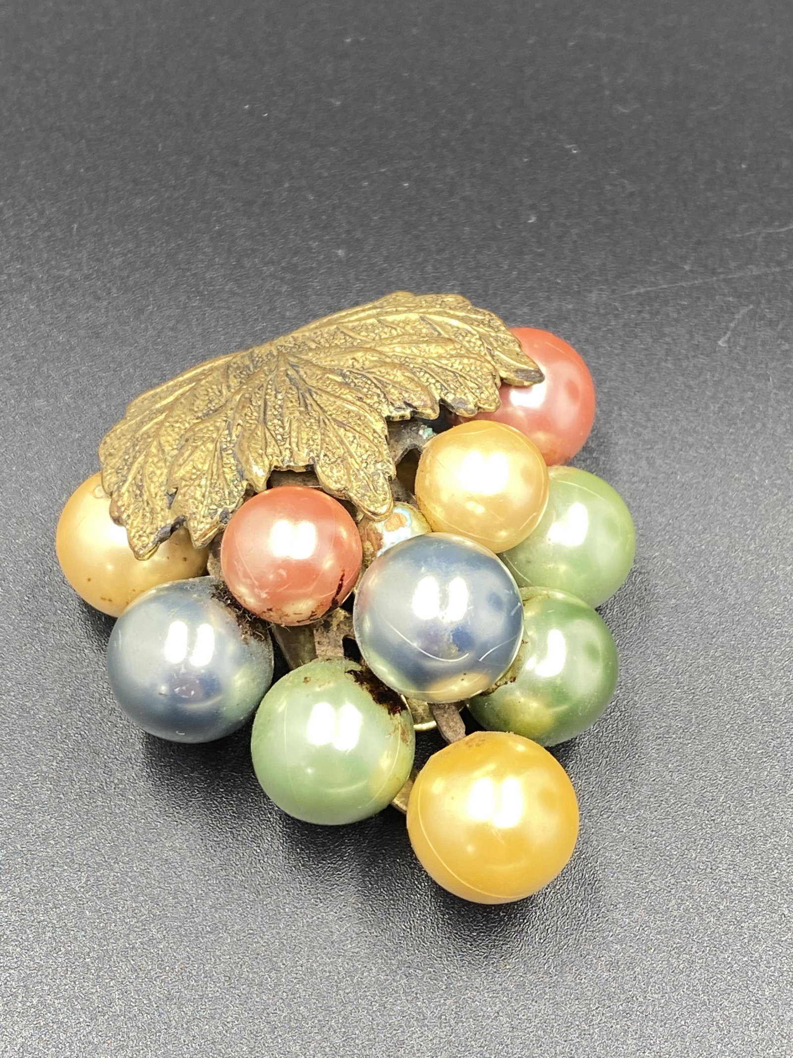 Colored Pearlized Grapes Dress Clip with Bronze Leaves: For exact dimensions please refer to the attached dimensions sheet. Bakelite was an early plastic resin, developed by Leo Baekeland in 1907. Originally used for industrial purposes thanks to its abili