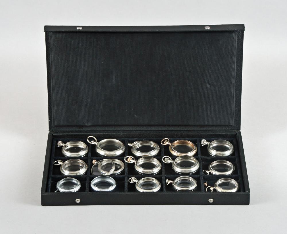 A lot of 15 display cases for pocket watches: A lot of 15 display cases for pocket watches, 18- 12 size, 14 nickel and one gold filled, with glazed front and back Details good to very good, gold filled case with brassing, one for a watch with int