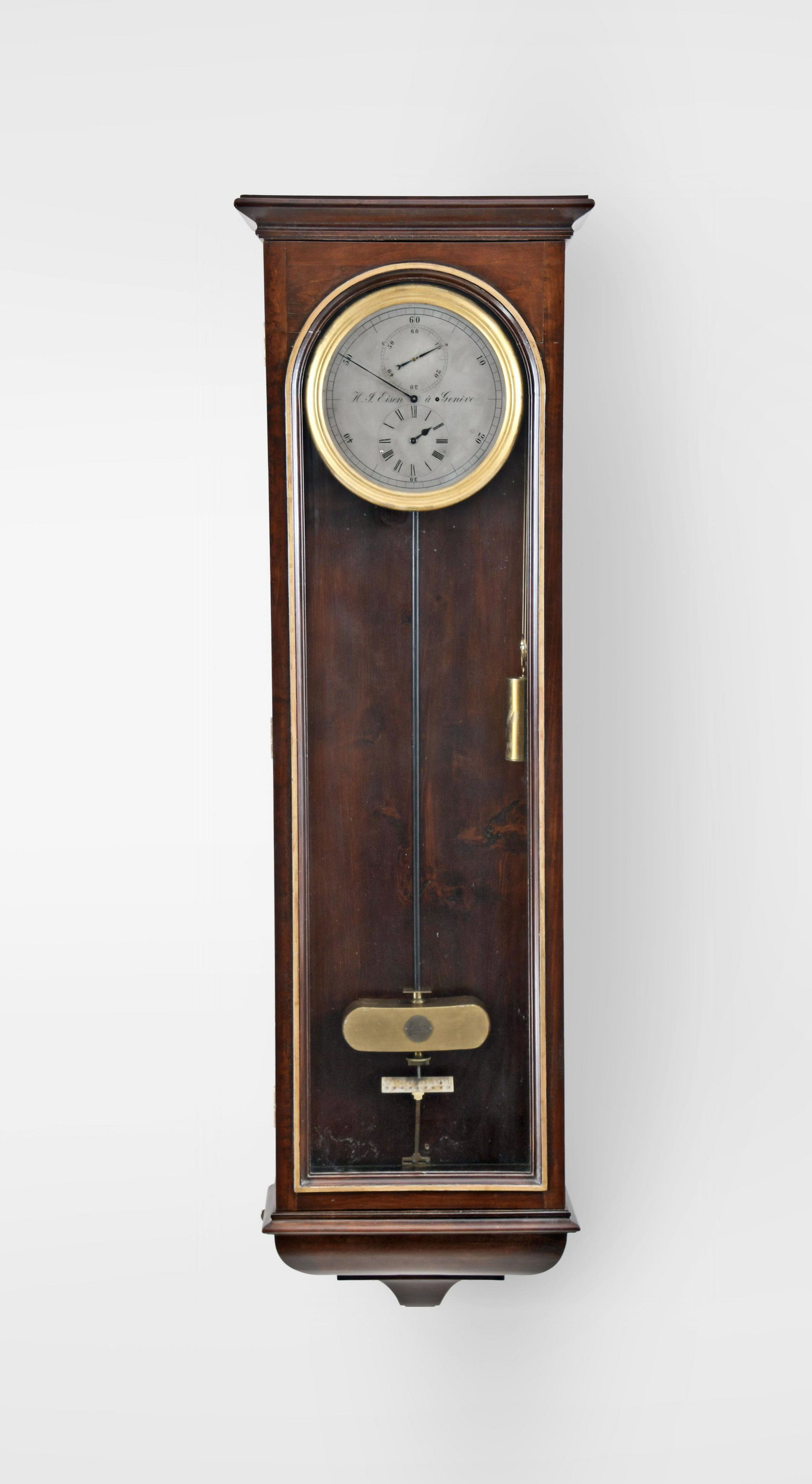 A hanging astronomical regulator signed H.J. Eisen a: H.J. Eisen, Geneva, a late 19th century hanging astronomical regulator, the softwood case with bold, molded bottom bracket, glazed door with arched aperture, and top with projecting, molded cornice, s