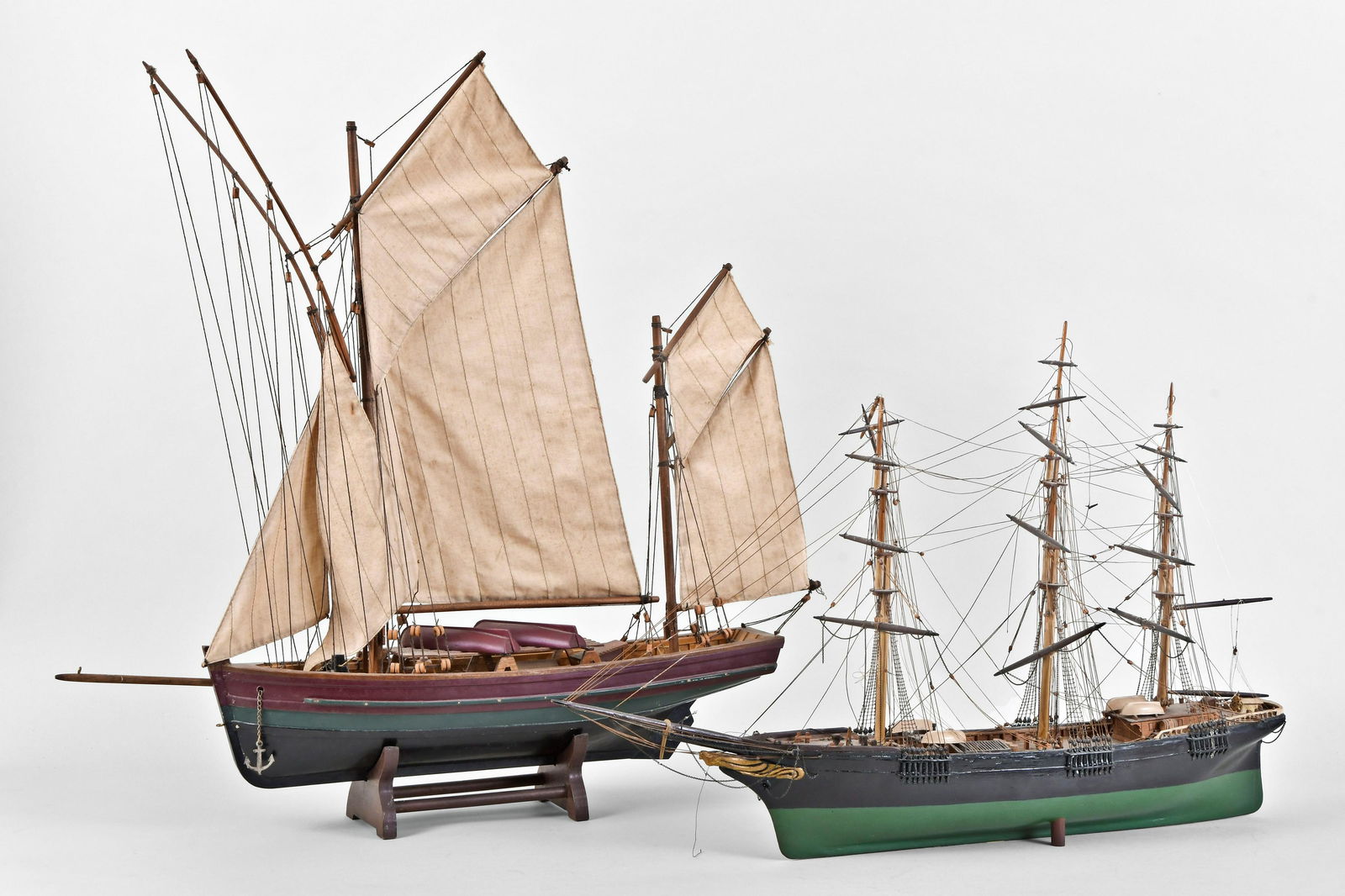 A lot of two wooden ship models: 2 (Two) wooden ship models,the first with black and green hull, three masts and rigging, the deck with life boats and barrels, the other with rigging and sails, and deck with lifeboats, dimensions of