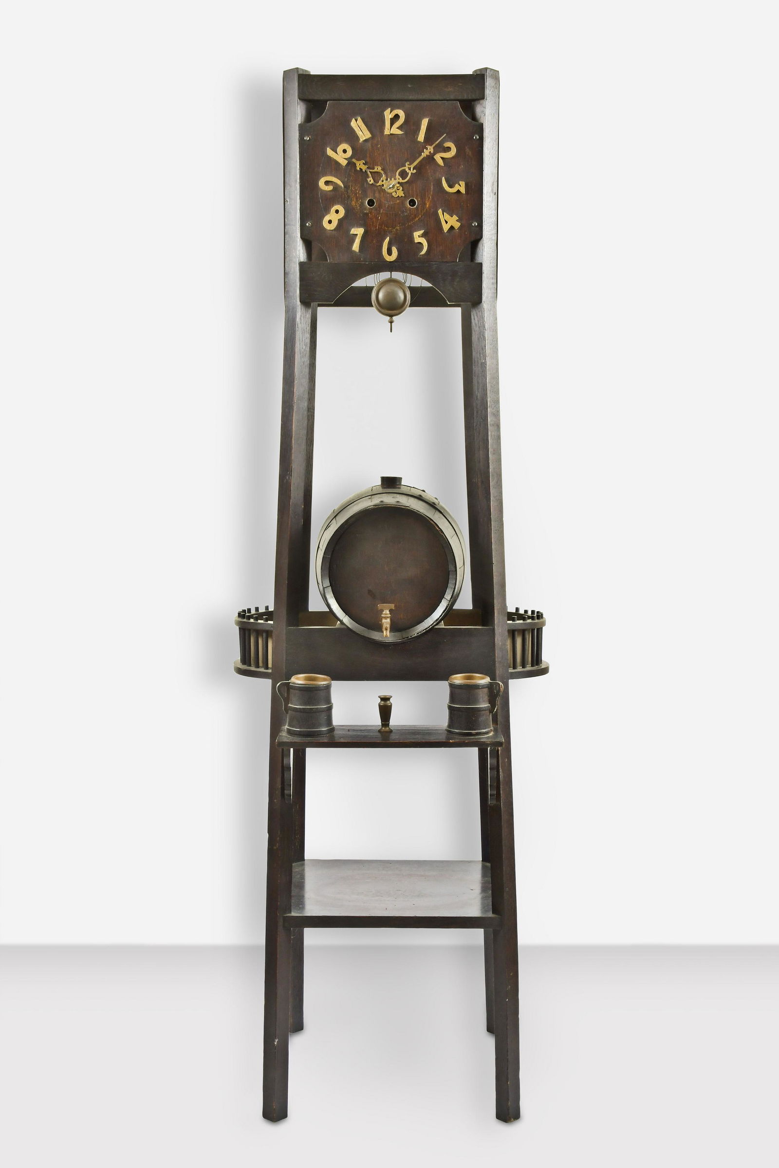 Mission Oak Style Tall Clock with Wine Cask: A Mission Oak style tall clock in ebonized walnut case featuring wine cask and two tankards below dial and shelf below cask, 8 day, time and strike on gong, spring driven movement stamped New Haven Cl