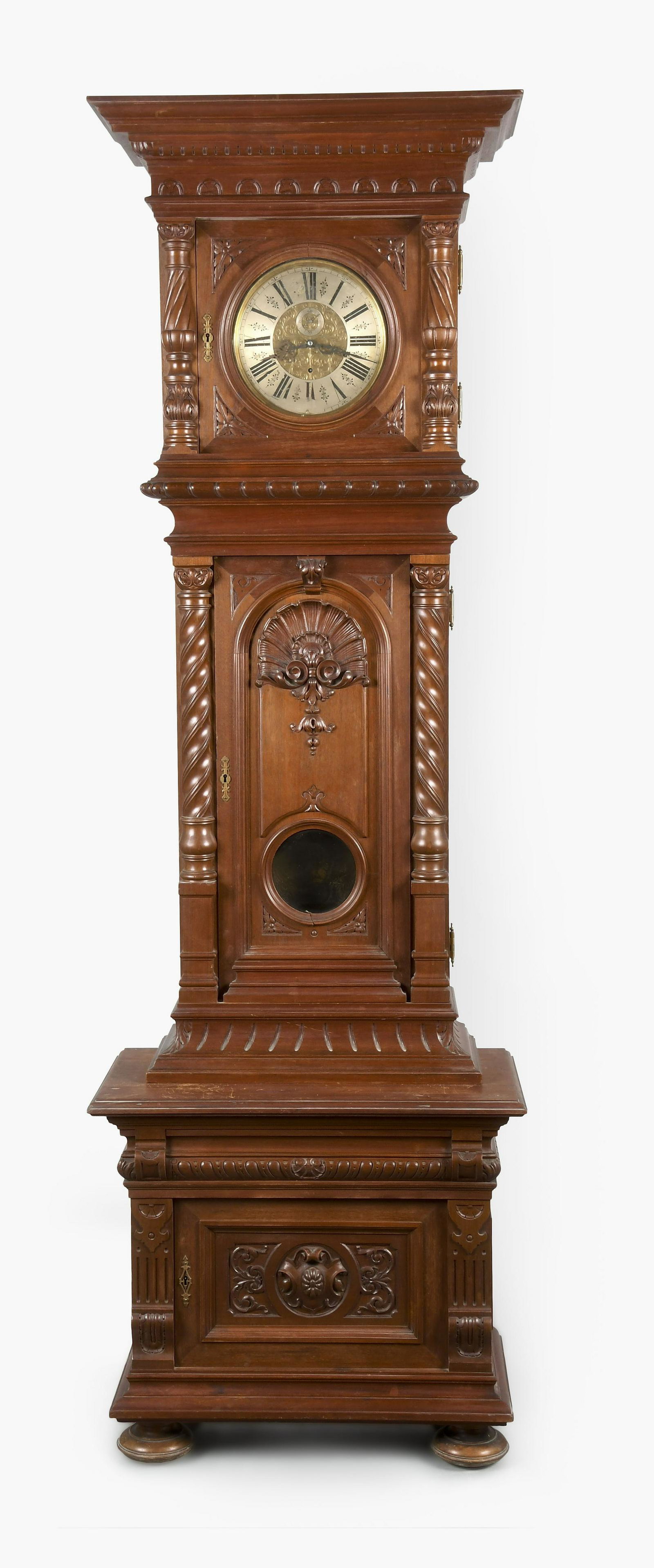 A month going grand sonnerie standing Vienna regulator clock: Germany, a month going grand sonnerie standing Vienna regulator in a carved walnut case with half columns flanking hood and trunk doors, aperture for pendulum bob, all resting on a base with cabinet a