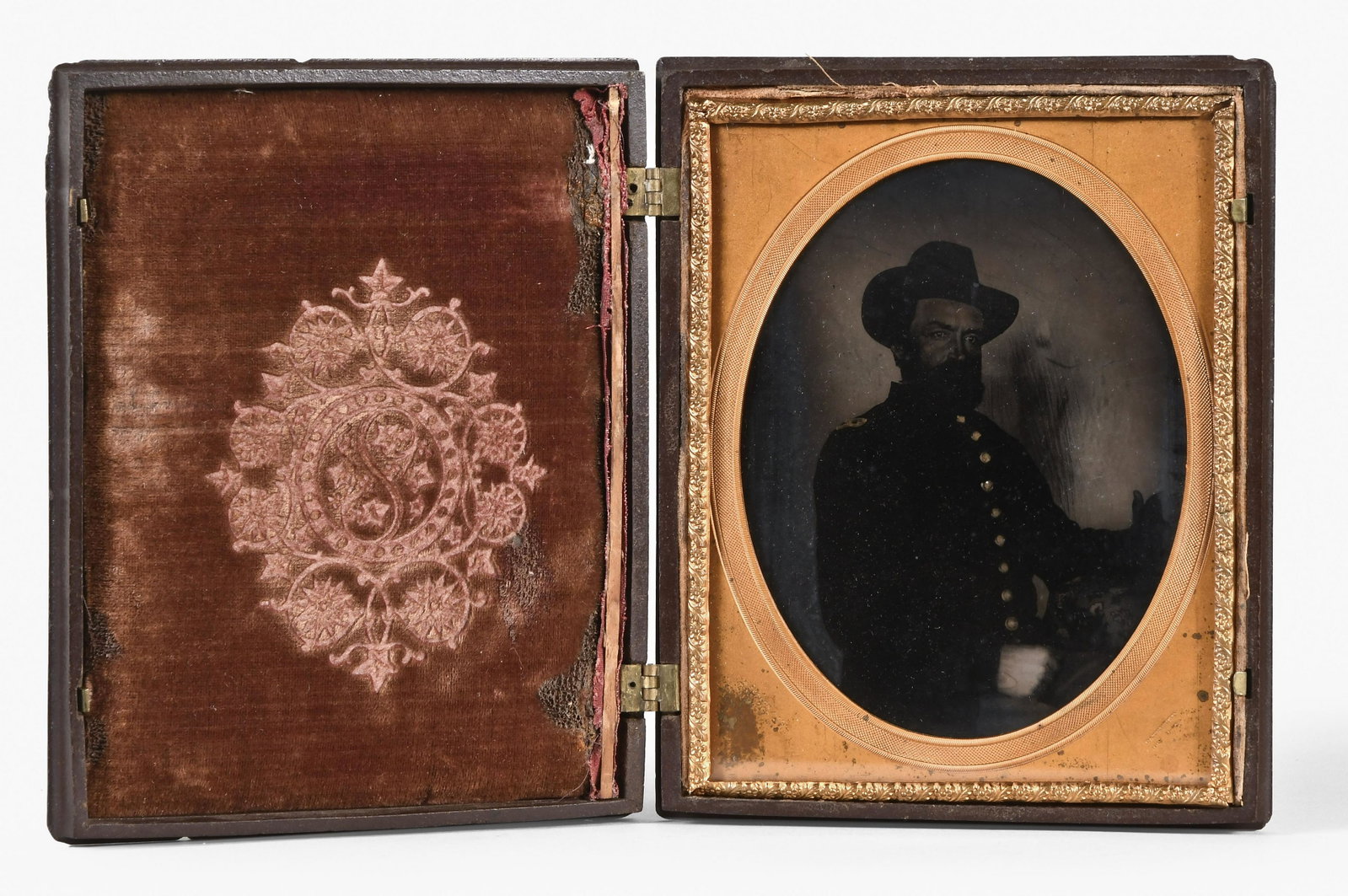 A half plate tintype of a civil war officer by A. Judson Newark: A Judson, Newark, N.J., a cased half plate tintype of a civil war officer, the seated gentleman in uniform and 3/4 profile, his coat with indistinct shoulder boards, his left arm resting on a table wi