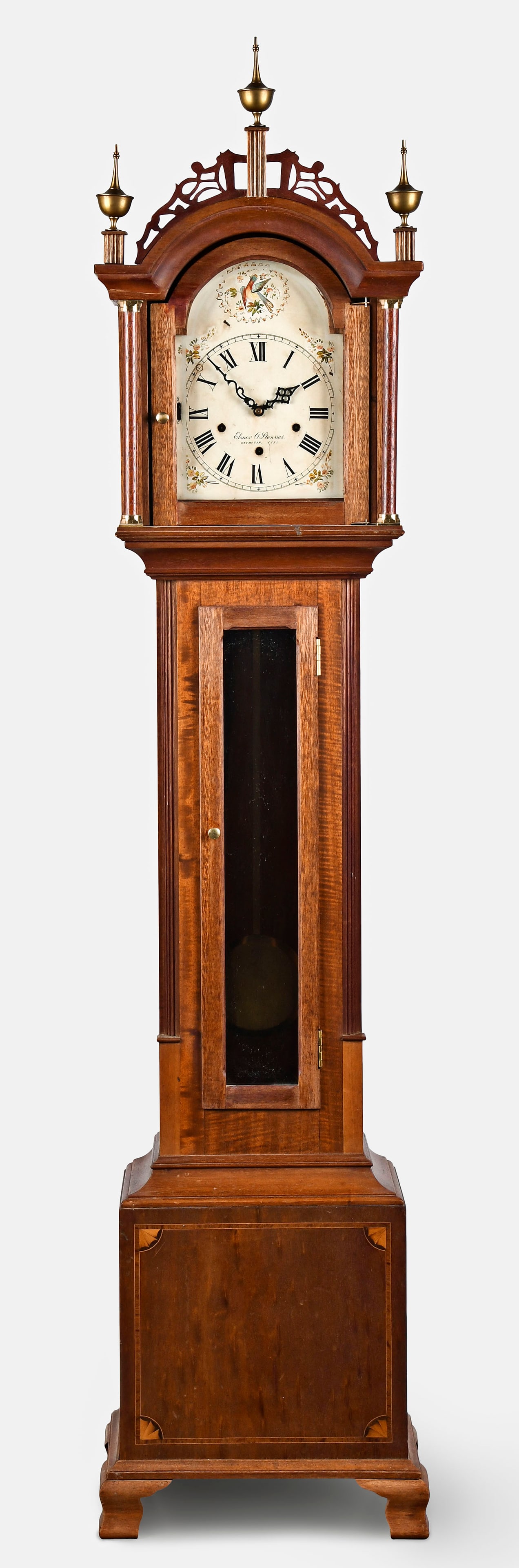 Three train grandmother clock with Stennes dial: Three train grandmother clock with Elmer O. Stennes, Weymouth, Mass. dial in a Roxbury style mahogany case with fretowrk top and reeded plinths and brass finials, trunk with reeded quarter columns and