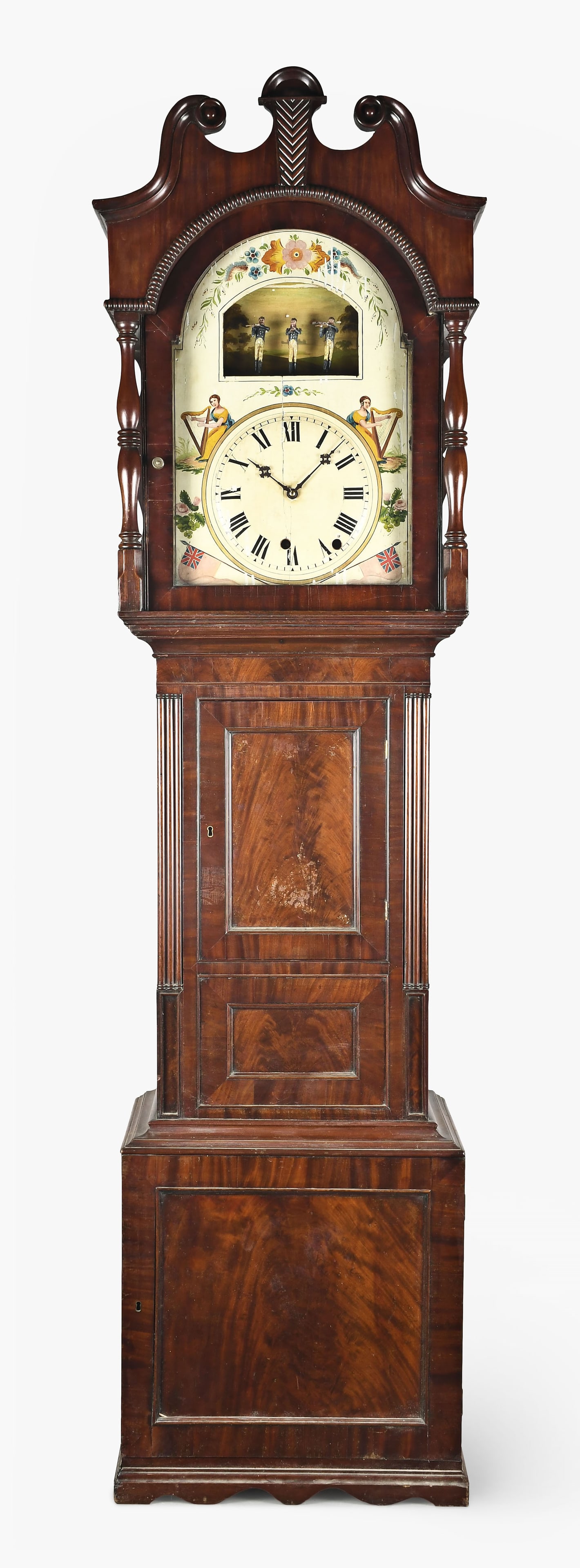 A 19th century German organ or flute tall clock: Germany, a 19th century organ or flute tall clock, the mahogany case with broken arch and beaded molding on crest, crotch mahogany panels, reeded columns flanking the trunk door, and resting on a slig
