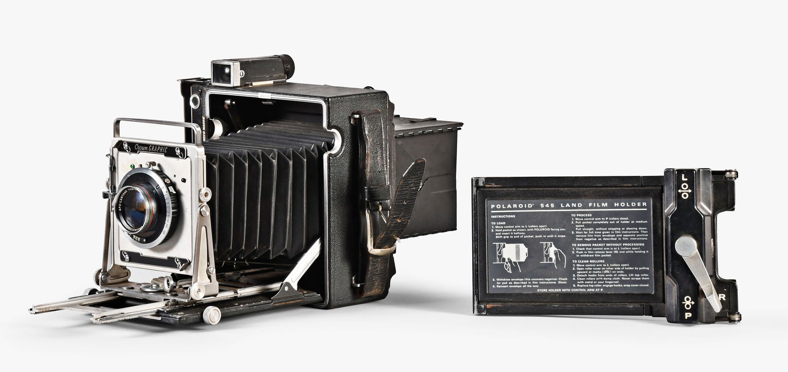 A lot of a press camera with a Voightlander Apo Lanthar lens and a range finder: 2 (Two) optical items including a Graflex synchronized range finder with 14.5 speed graphic press camera with Voightlander Apo Lanthar 4.5-15cm lens, circa 1950, and a Bausch and Lomb WW I military ra