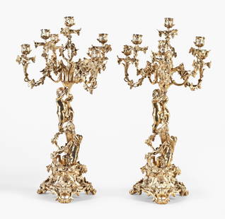 An exceptional pair of late 19th century French rococo gilt bronze candelabra: France, an exceptional pair of late 19th century rococo gilt bronze candelabra, each with provision for seven candles supported by scrolled arms with acanthus, grape cluster and vine ornament, the col