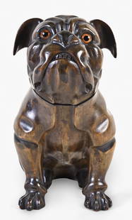 A good early 20th century Black Forest carved linden bulldog form tobacco box: Germany or Switzerland, a good early 20th century Black Forest carved linden bulldog form tobacco box, the full body figure seated and looking up with glass eyes, the head hinged and concealing a well