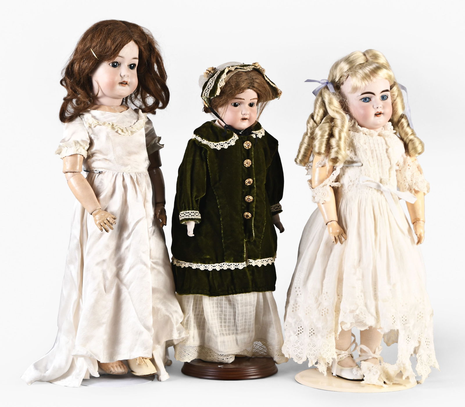 A lot of three German bisque dolls by Marseille, Simon & Halbig, and Bergmann: 3 (Three) German bisque dolls, the first a 1916 /6 1/2a by C.M. Bergmann, socket head with blue sleep eyes and open closed mouth with four teeth, jointed composition body, and white dress, 23in, the n