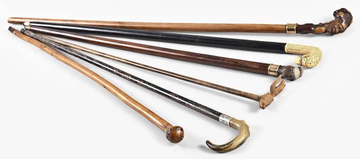 A lot of twenty-one canes and walking sticks: 21 (Twenty-one) canes and walking sticks made from various woods including bone handled, homemade with figural handles, two sword canes, compass, pool cue, camera tripod, and others