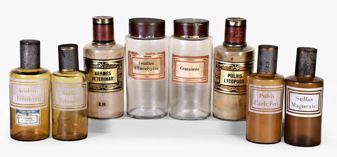A lot of eight late 19th century French apothecary jars with tin lids: 8 (Eight) late 19th century French apothecary jars, the shouldered cylindrical containers with pontilled bases and decorated tin lids, four in colorless glass, and four in amber