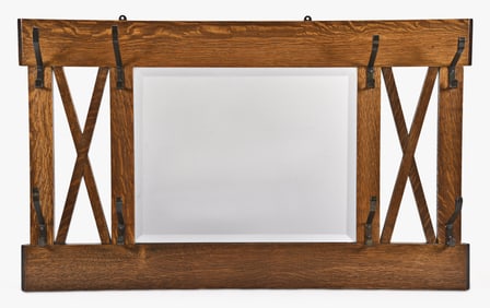 An early 20th century Arts & Crafts style hanging hall mirror with eight coat and hat hooks