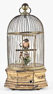 A French singing bird automaton: France, singing bird automaton, spring driven movement powers the singing bird, producing song and head, beak and tail feather motion, mounted on eight sided gilt wooden base with applied floral ornam