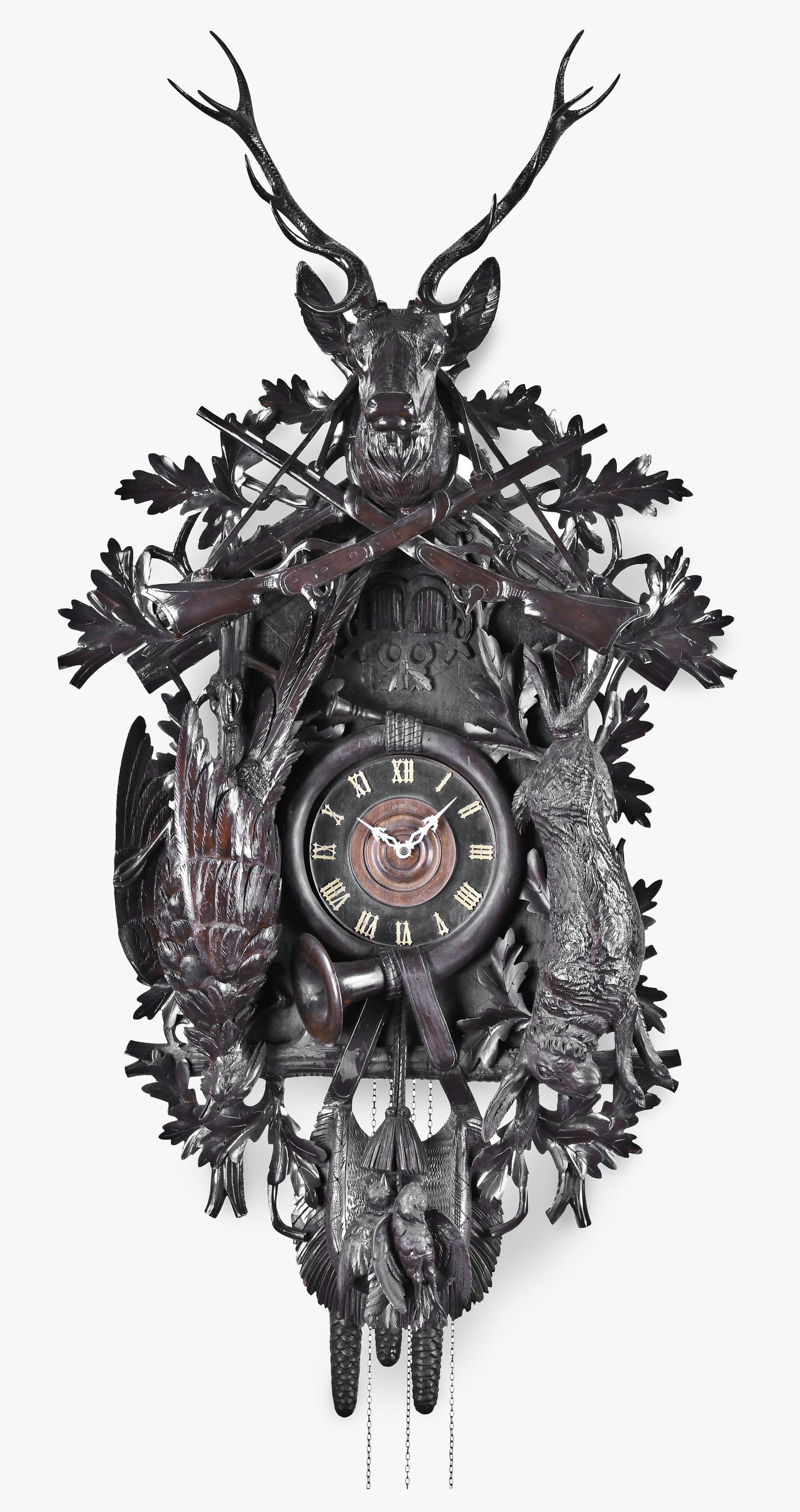 A very large Black Forest hunter motif cuckoo & quail clock: Germany, a very large Black Forest hunter motif cuckoo clock, the case with well carved oak leaf and lattice ornament, stag head with glass eyes and 13 inch antlers, above a hanging rabbit, pheasant a