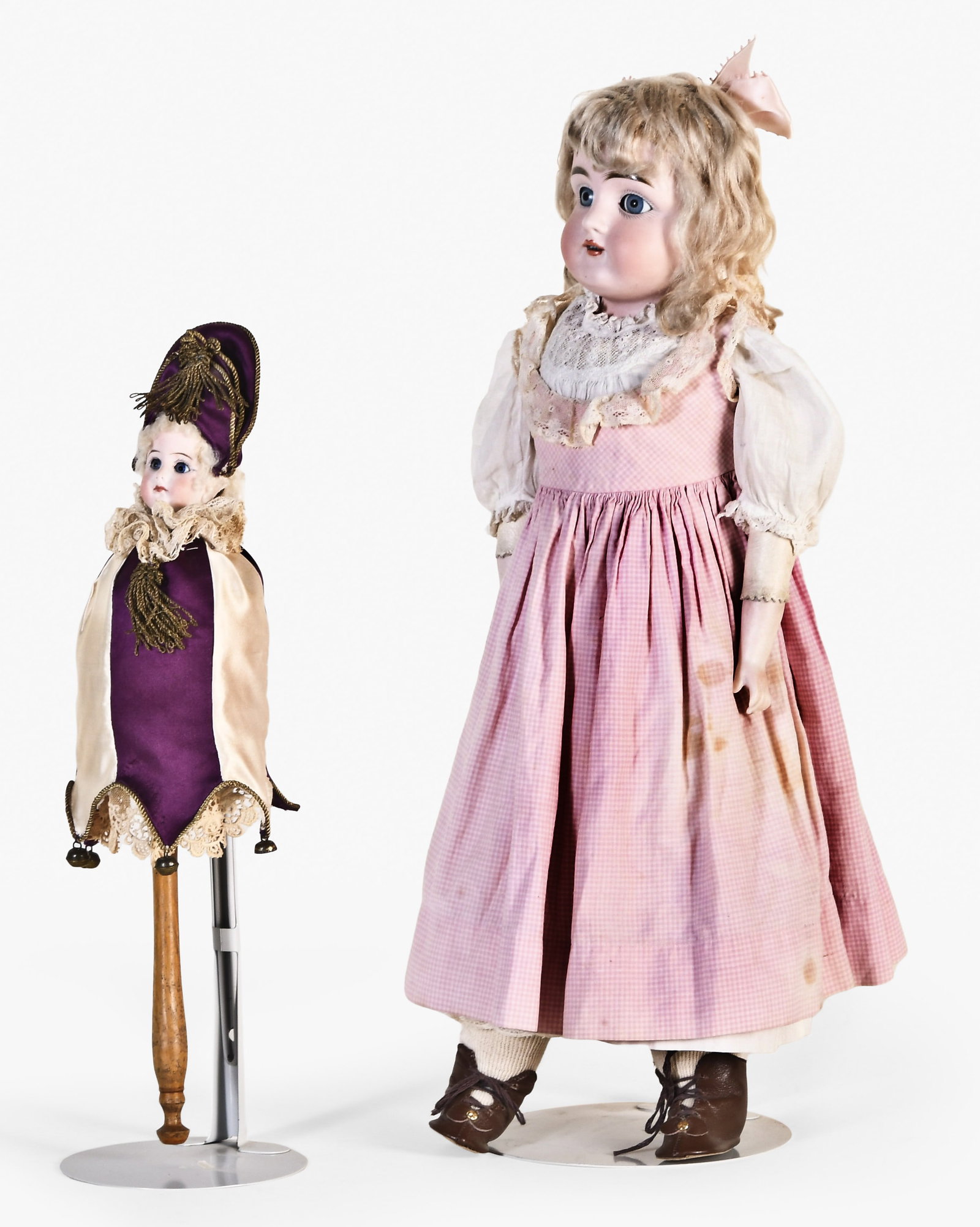 A 20 inch Kestner 154 and a musical marotte with bisque head: 2 (Two) dolls, the first a 20 inch Kestner 154, the back of the head marked "D 8 154", with blue sleep eyes, open mouth with four teeth, blond wig, kid body with bisque forearms, pink dress with lace 