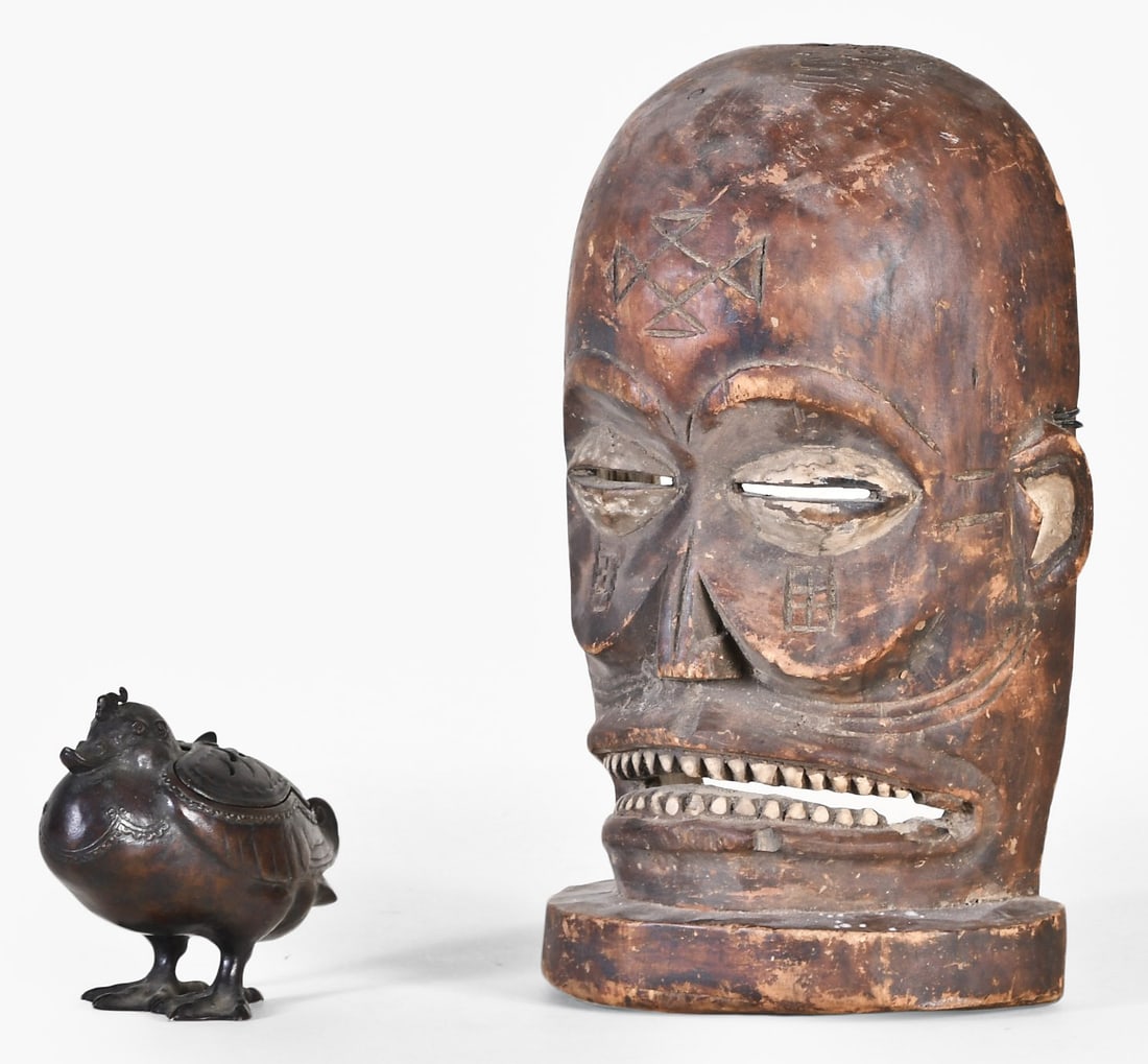 An Asian bronze duck form incense burner and a carved wooden Chokwe mask: A lot of two 20th century decorative objects including a patinated bronze duck form incense burner, the back with crescent shaped apertures, together with an Angolan carved wooden Chokwe Chihongo mask