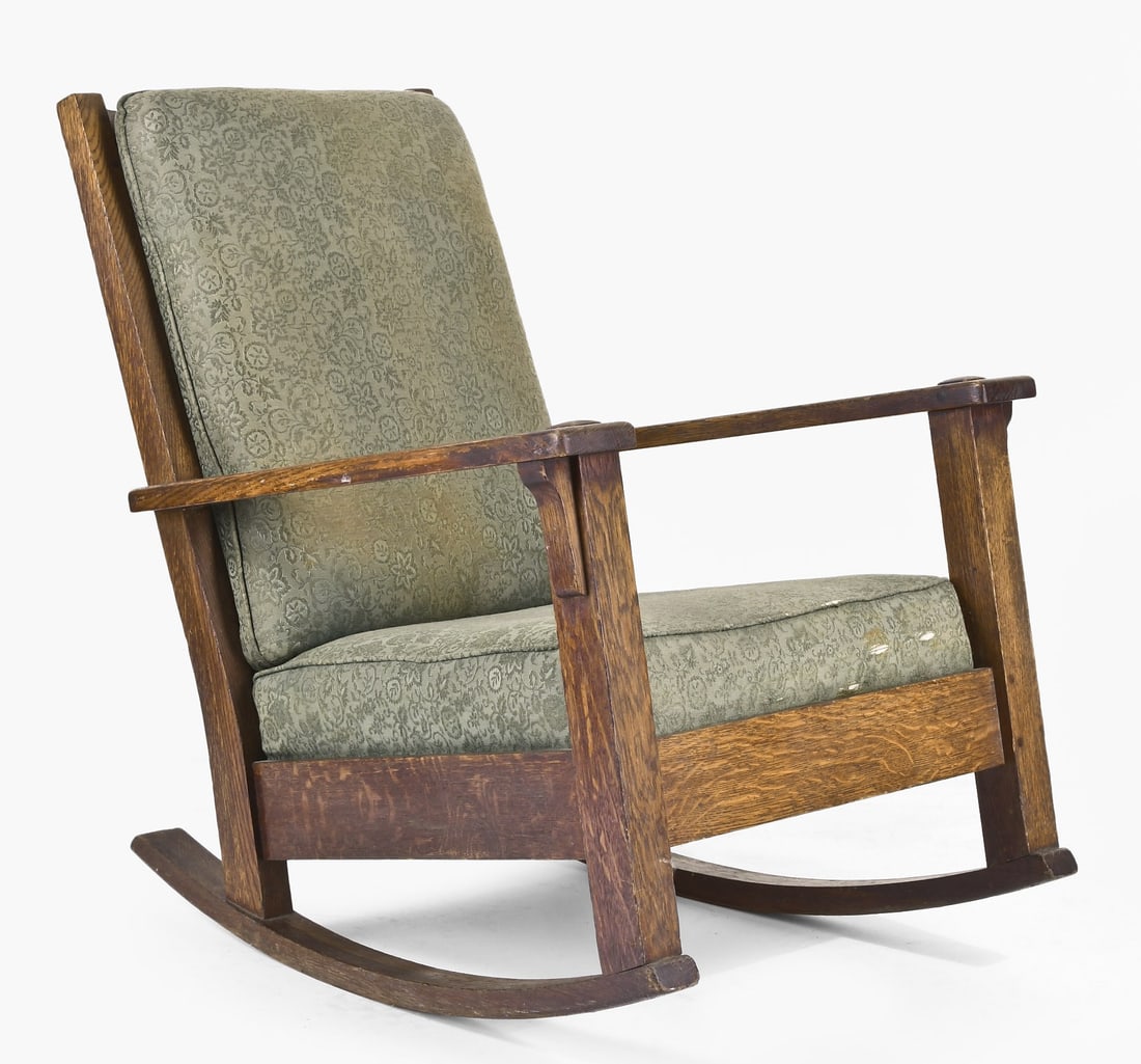 An early 20th century Arts & Crafts style rocking chair by Limbert: Charles P. Limbert Co., Grand Rapids and Holland, Michigan, an early 20th century rocking chair with upholstered seat and back cushions, in the typical Mission style and with through tenons at the joi