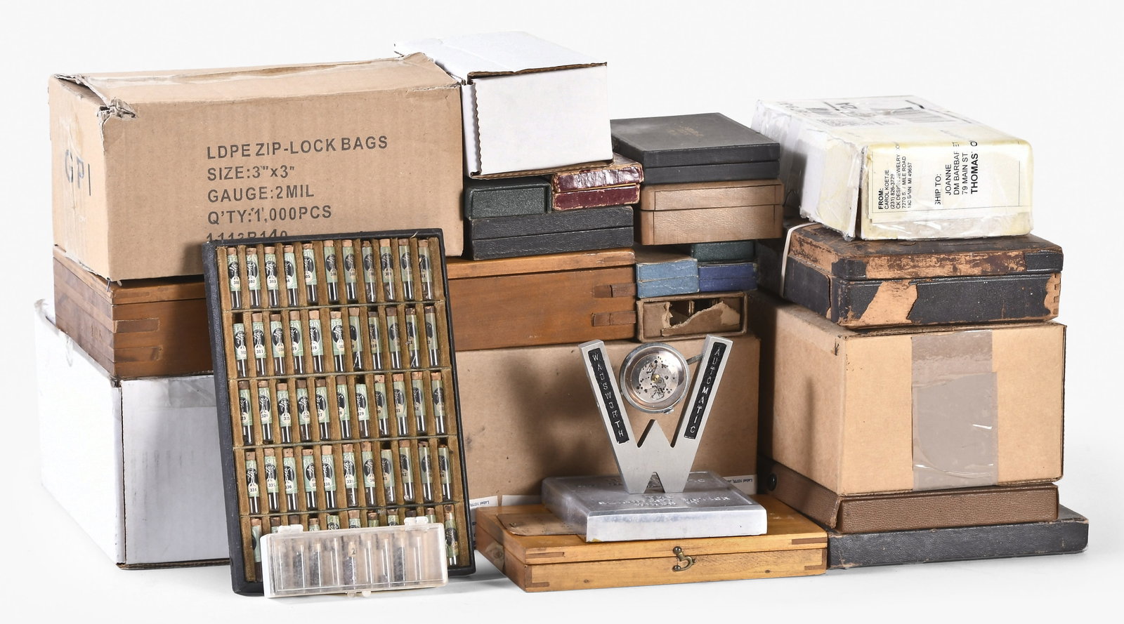 A lot of watchmaker's parts and material: A lot of watchmaker's parts and material for makers including Elgin, Rockford, Hampden and Waltham, two wooden factory boxes filled with third wheel pinions and barrel arbors for Elgin or Hamilton mar