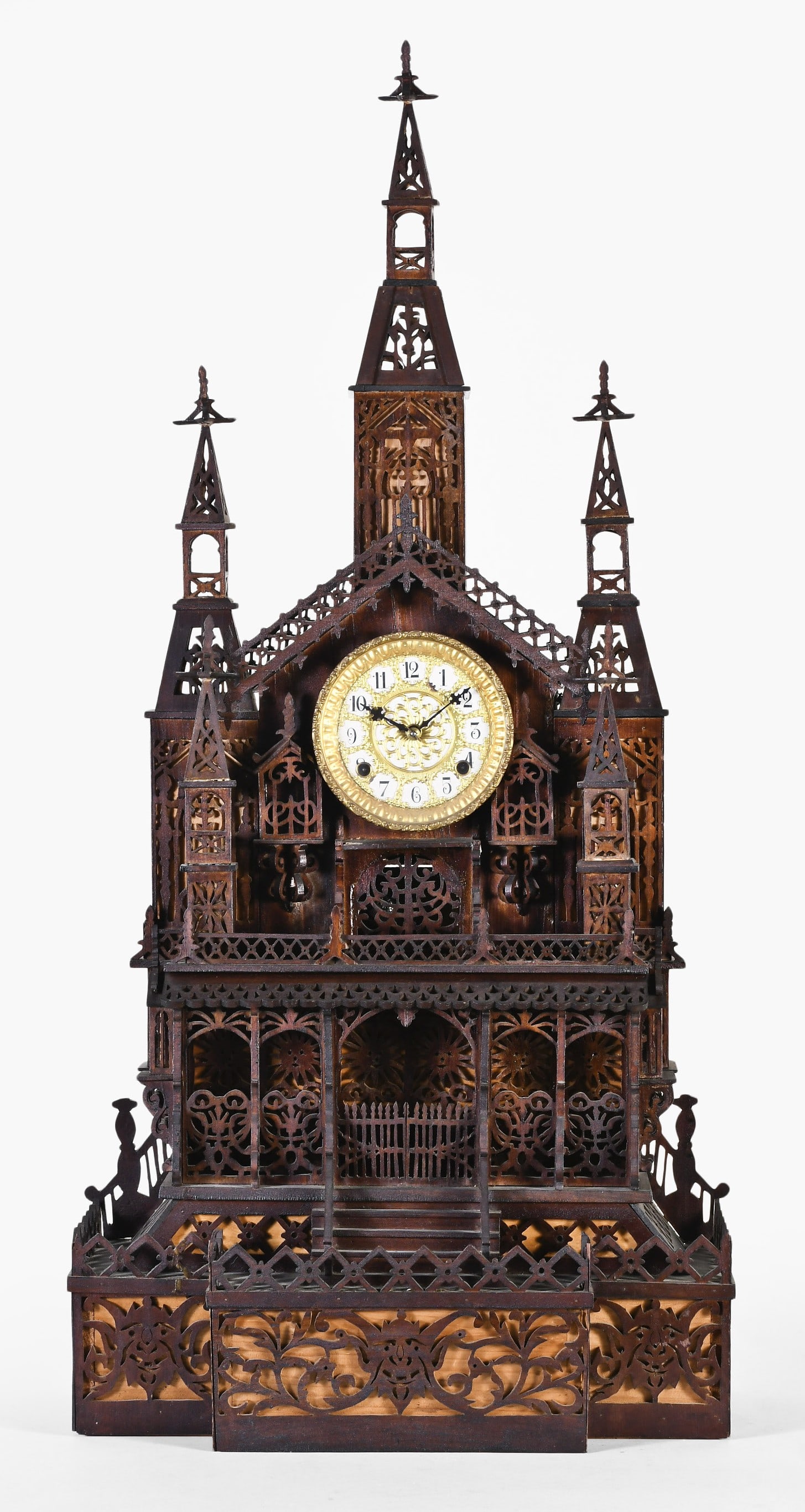 A large early 20th century cathedral form mantel clock with fretwork case: A large early 20th century cathedral form mantel clock, the architectural fretwork case in the Gothic style, with scroll form and geometric piercing and profiles, containing an eight day time and stri