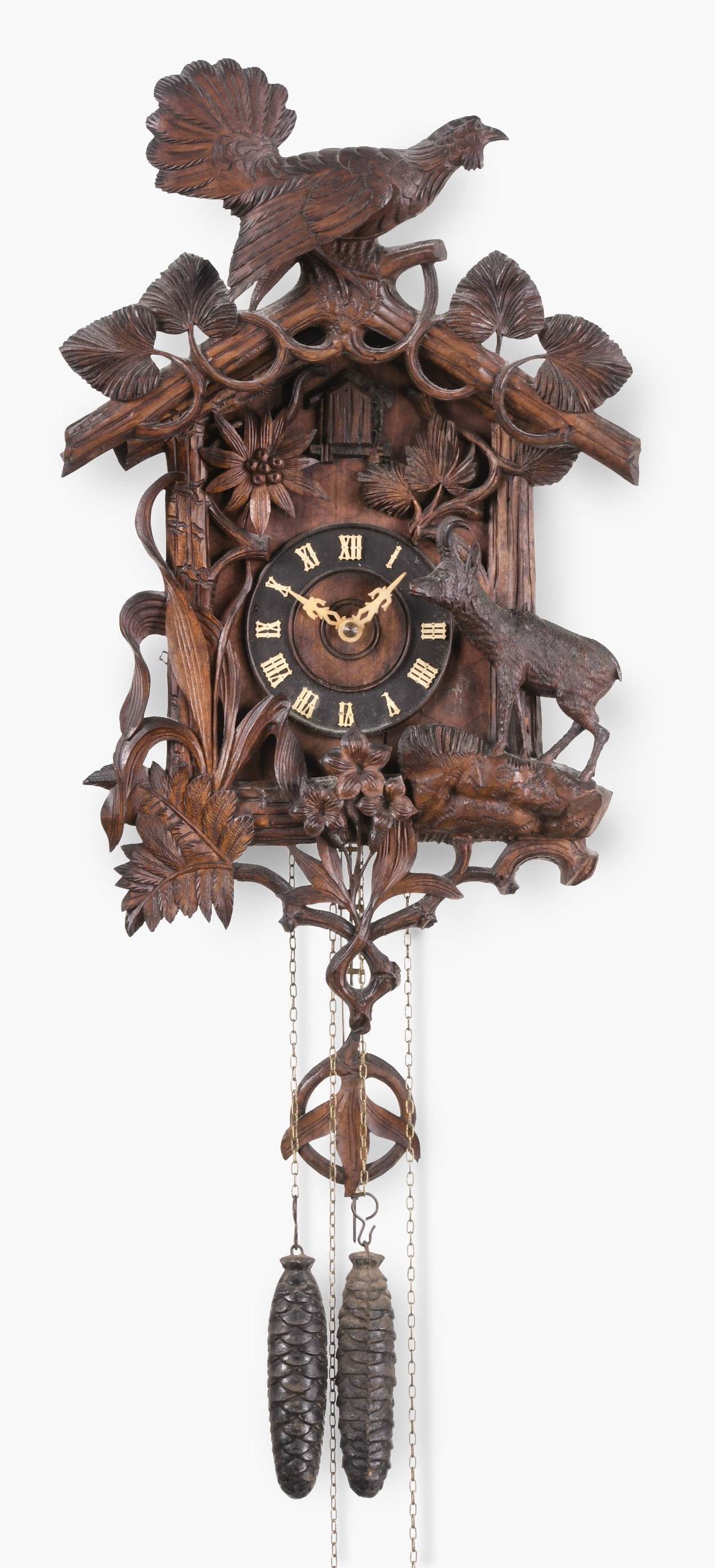 Gordian Hettich & Sohn cuckoo clock in mountain motif: Gordian Hettich & Sohn, Germany, carved Black Forest woods motif with mountain goat in full relief amid brush, vines, leaves, ferns, and blooming edelweiss, crest crowned by an auerhahn poised above t
