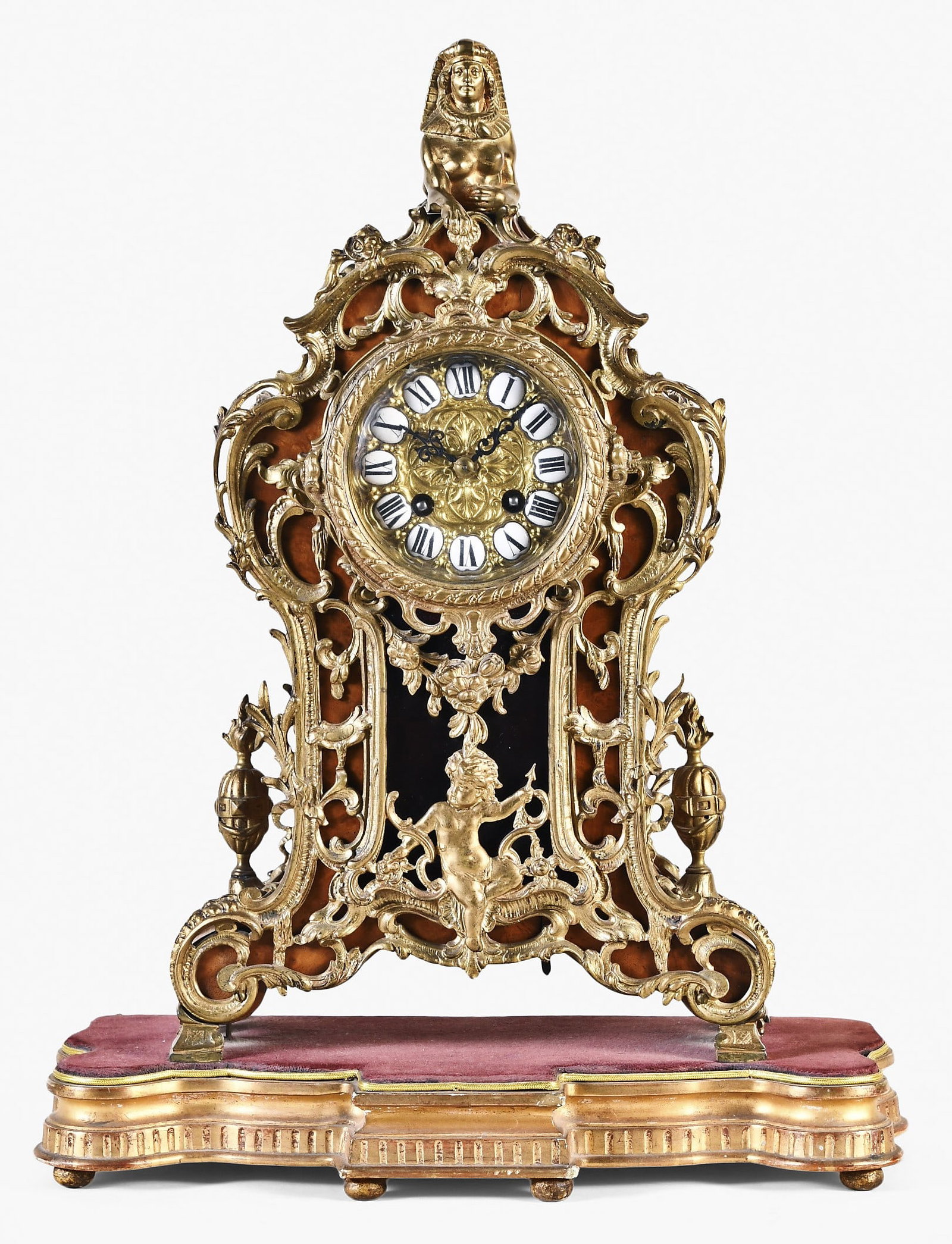 A Gustav Becker shelf clock for the French market: Gustav Becker, Germany shelf clock for the French market in a walnut veneered case, profusely decorated with gilt brass trim in the Egyptian Revival style, the round movement is made in the Paris
