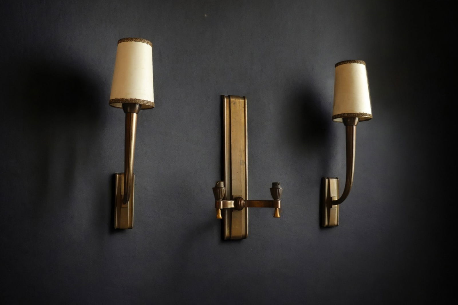Jean PASCAUD (1903-1996) Set consisting of a double sconce and a pair of single sconces in patinated: Jean PASCAUD (1903-1996) Set consisting of a double sconce and a pair of single sconces in patinated gilt bronze. - Weight: 5.68 kg - Shipping unavailable - Region: France - Sizes: H 460MM X L 220MM P