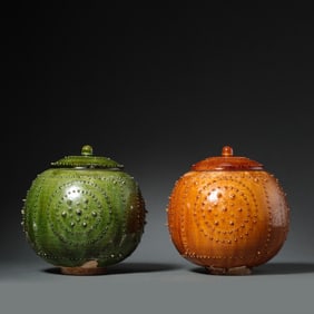 A pair of Chinese Sui Dynasty yellow-green glaze drum-shaped lidded jars